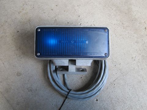 1991 Ford LTD Crown Victoria - A blue strobe light is mounted on a bracket with a coiled cable attached.