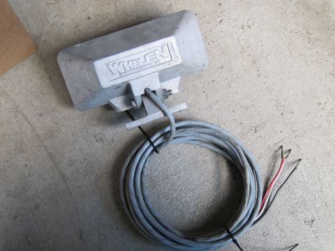 1991 Ford LTD Crown Victoria - A Whelen siren speaker, likely for emergency vehicles, rests on a concrete surface with its wiring exposed.