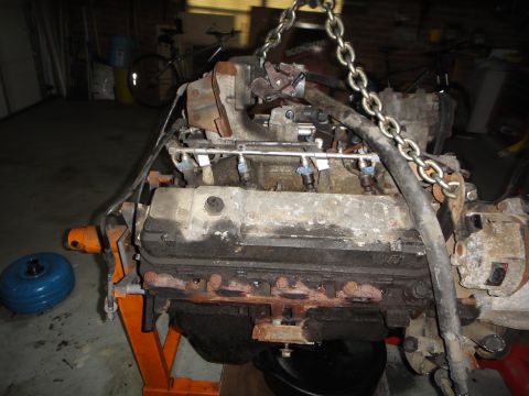 1994 Ford Bronco - Engine assembly hoisted on an orange engine stand, ready for installation or repair.