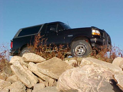 1995 Ford Bronco - This 1995 Ford Bronco is navigating a rocky obstacle course under a clear blue sky.