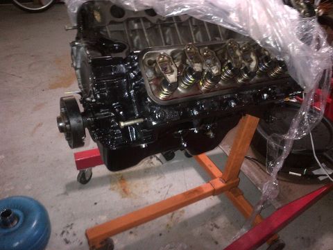 1994 Ford Bronco - A black V8 engine, possibly a Ford 460, is shown on an engine stand, partially covered in plastic wrap.