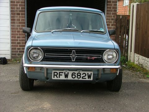 1980 MINI Cooper - Front view of a light blue 1980 MINI Cooper parked in front of a garage.