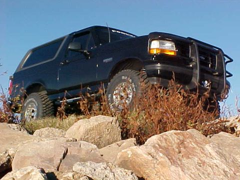 1995 Ford Bronco - This 1995 Ford Bronco is parked on a rocky incline with dry brush surrounding it.