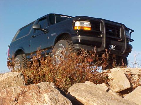 1995 Ford Bronco - This black 1995 Ford Bronco navigates a rocky terrain, its off-road capabilities.