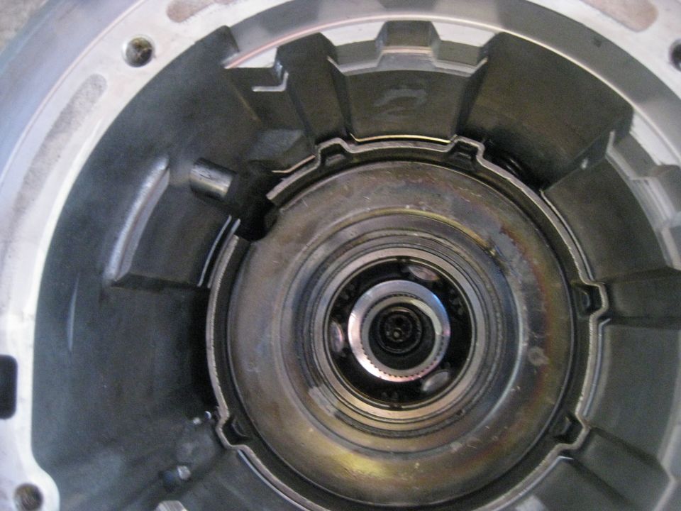In this picture the anit-clunk spring can be seen in the upper right between the case and planetary gearset. It is installed with the tabs pointing up.