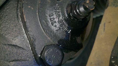 1978 Ford Bronco - A close-up view of a vehicle part shows stamped identification numbers and some grease.