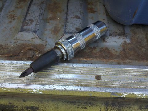 1978 Ford Bronco - A close-up view of a chrome and black impact screwdriver bit holder with a Phillips head bit.
