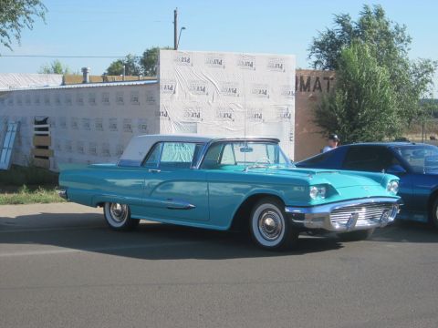 1991 Ford LTD Crown Victoria - Turquoise 1958 Ford Thunderbird coupe parked on street, with another car behind it.