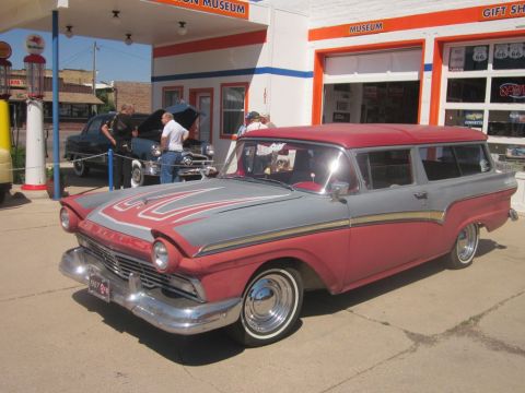 1991 Ford LTD Crown Victoria - A vintage two-tone station wagon is parked in front of a classic gas station and museum.