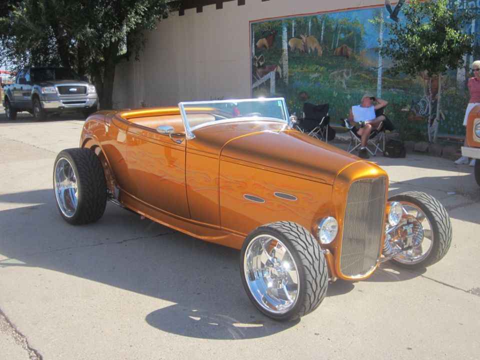 Orange hot rod convertible with chrome wheels and exposed engine parts