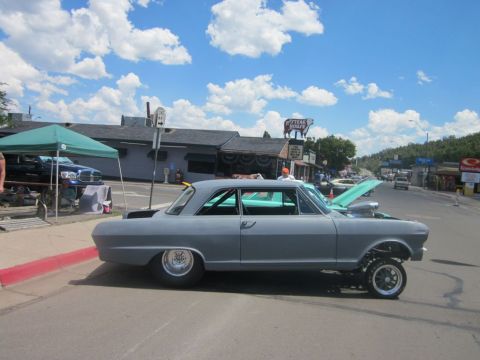 1991 Ford LTD Crown Victoria - A gray hot rod car with a roll cage and exposed engine sits on a street during a car show.