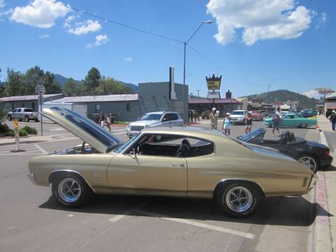 1991 Ford LTD Crown Victoria - A classic gold Chevrolet Chevelle SS is displayed with its hood up at an outdoor car show.