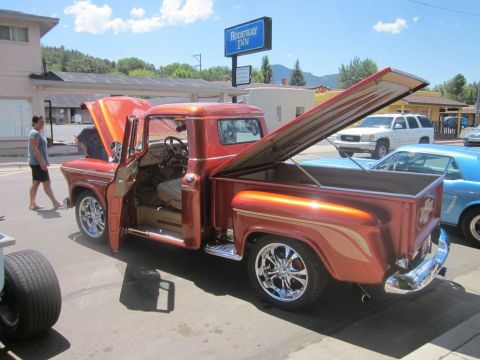 1991 Ford LTD Crown Victoria - A custom orange pickup truck is displayed with its hood and bed open at an outdoor car show.