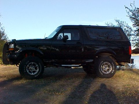 1995 Ford Bronco - This black Ford Bronco, likely from the early to mid-1990s, is shown from its side profile.