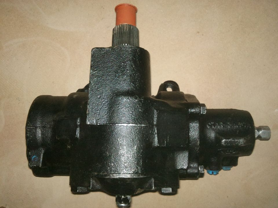 Black steering gear box with orange cap on splined shaft