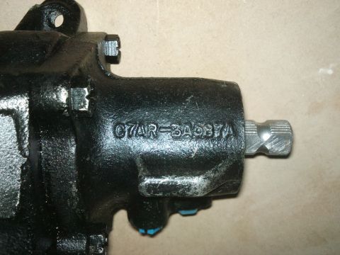 1998 Ford Crown Victoria - Close-up of a black steering gear assembly, showing stamped part numbers.