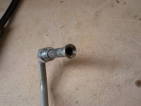 1998 Ford Crown Victoria - A metal hose fitting with a threaded connection is shown against a textured background.