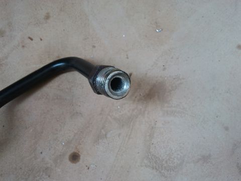 1998 Ford Crown Victoria - A close-up view of a metal pipe fitting, likely a component from a vehicle's steering system.