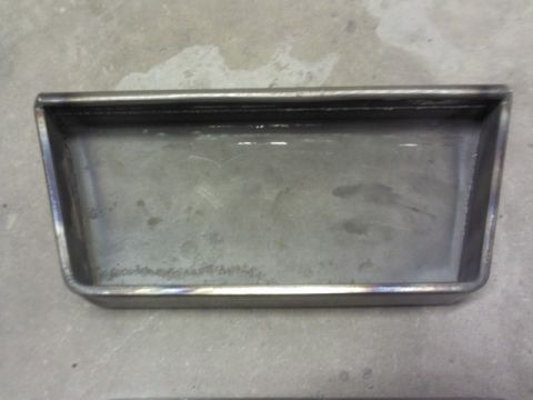 1993 Ford F-150 - A metal tray with visible weld marks sits on a concrete surface.
