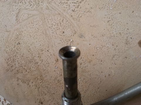 1998 Ford Crown Victoria - Close-up of a metal pipe fitting, likely a component from a vehicle's steering system.