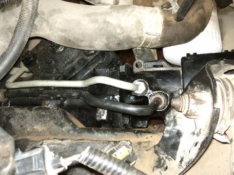 1998 Ford Crown Victoria - Close-up view of a vehicle's steering gear assembly, showing hydraulic lines and mechanical components.