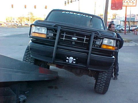 1995 Ford Bronco - This 1995 Ford Bronco is being loaded onto a tow truck, with a skull and crossbones decal on the grille guard.
