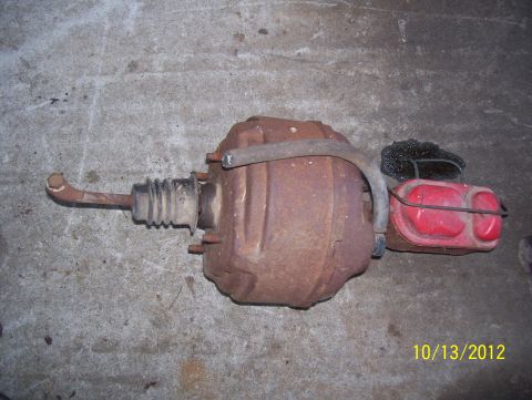 1990 Ford Bronco - A used brake booster and master cylinder assembly is shown on a concrete surface.