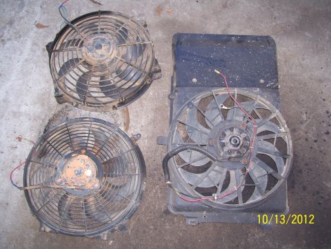 1990 Ford Bronco - A collection of used radiator fans, likely for sale or repair, are laid out on a concrete surface.