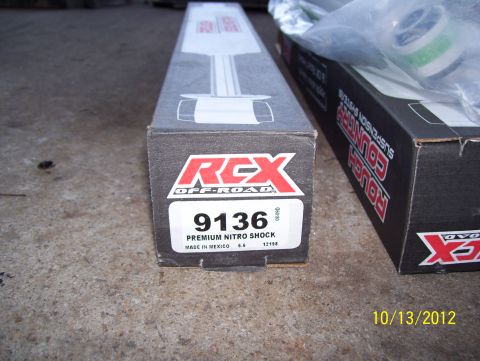 1990 Ford Bronco - Two boxes of suspension parts, one RCX Off-Road and one Rough Country, sit on a concrete surface.