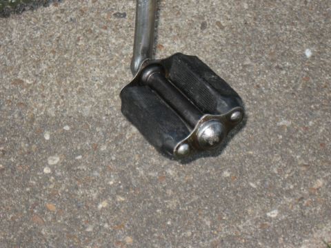 1994 Ford Bronco - A close-up view of a bicycle pedal with textured black rubber grips and metallic end caps.