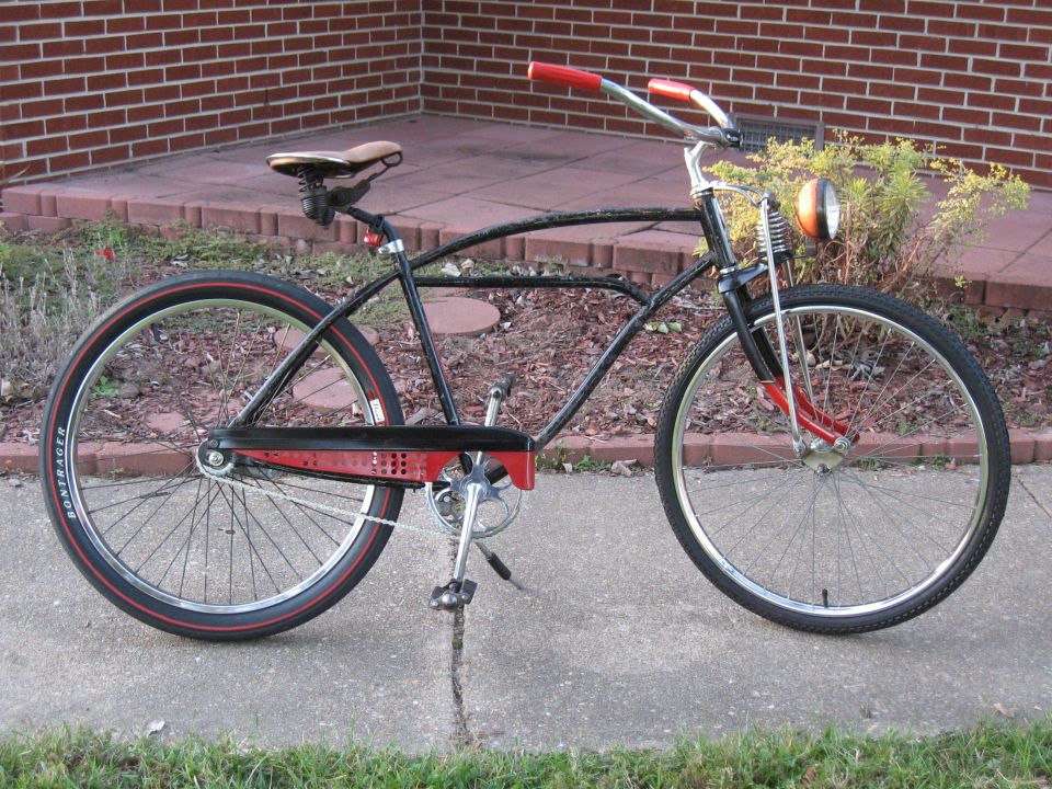 Black bicycle with red accents and a headlight, seen from the side