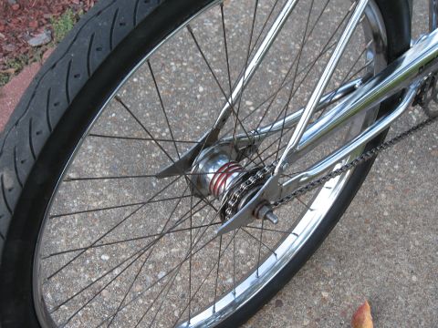 1994 Ford Bronco - Close-up of a bicycle's rear wheel, showing the spokes, chrome frame, and chain.