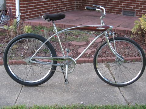 1994 Ford Bronco - A custom cruiser bicycle is parked on a sidewalk in front of a brick house.