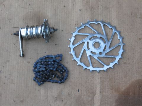 1994 Ford Bronco - A bicycle chain, hub, and sprocket are displayed on a textured surface, suggesting parts for a bike build or repair.
