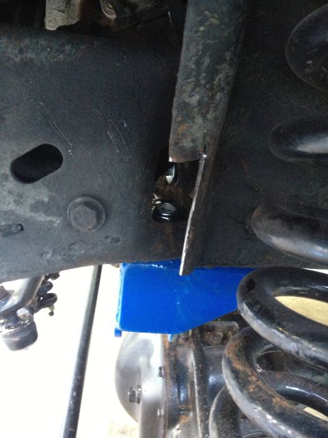 1996 Ford F-150 - A blue suspension block is installed near the coil spring on a vehicle's frame.