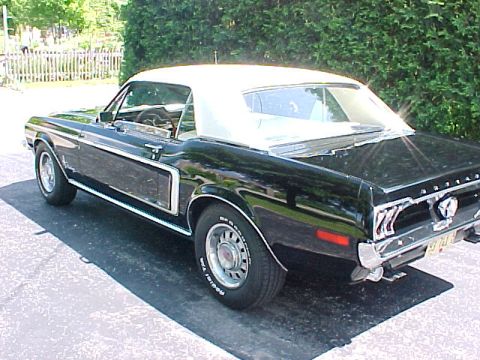 1969 Ford Torino - Rear quarter view of a black convertible with a white top. The vehicle appears to be a 1969 Ford Mustang.