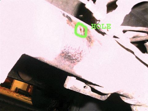1990 Ford Bronco - Close-up of rusted metal showing a hole, with text overlay and website logo.