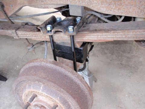1995 Ford Bronco - Vehicle's rear axle leaf spring with a U-bolt lift kit being installed.