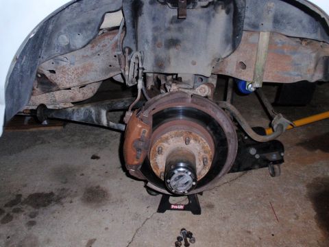 1995 Ford Bronco - Close-up view of the front wheel assembly, the brake caliper and suspension components, likely related to a lift kit installation.