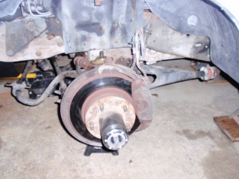 1995 Ford Bronco - The front suspension and braking system of a vehicle are shown in detail, supported by jack stands.