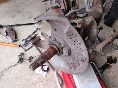 1995 Ford Bronco - Close-up of a disassembled vehicle suspension component with various tools scattered around.
