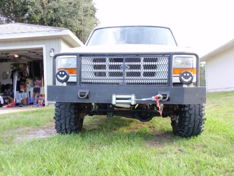 1995 Ford Bronco - This 1995 Ford Bronco features a heavy-duty custom front bumper with an integrated winch and unique smiley face headlights.