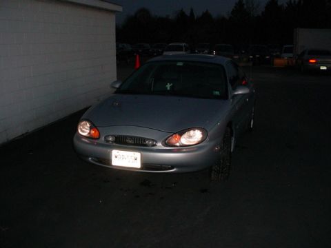 1999 Mercury Sable - This silver 1999 Mercury Sable sedan is seen from the front at night, parked near a building.