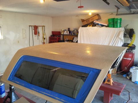 1996 Ford Bronco - A vehicle roof panel is being worked on in a garage setting, with tools and equipment visible in the background.