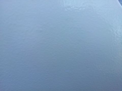 1996 Ford Bronco - Close-up of a light blue fender panel, showing its textured paint finish.