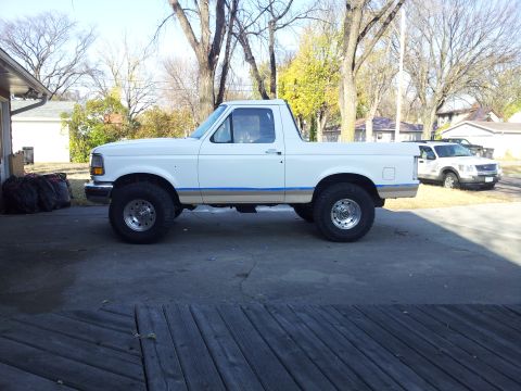 1996 Ford Bronco - Side view of a white 1996 Ford Bronco parked in a driveway.