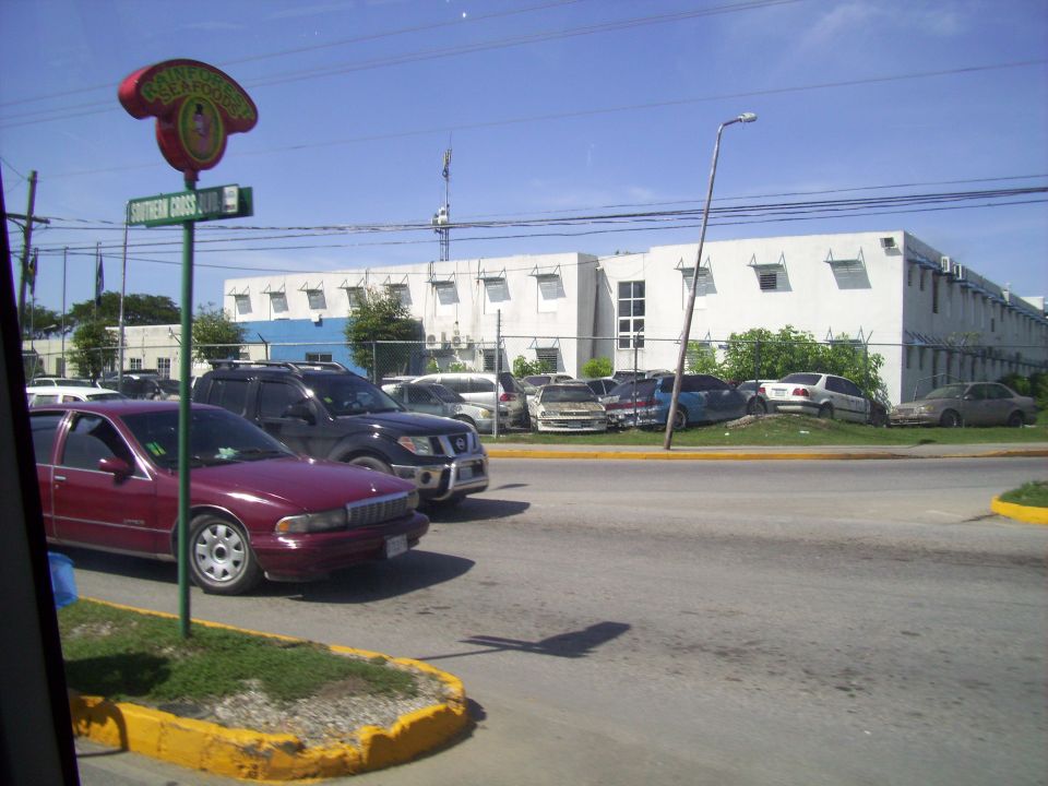 Cars parked in lot near a building with a sign that says "SOUTHERN CROSS"