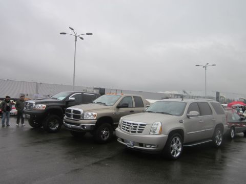 1991 Ford LTD Crown Victoria - Several trucks and an SUV are parked in a lot on a cloudy day.