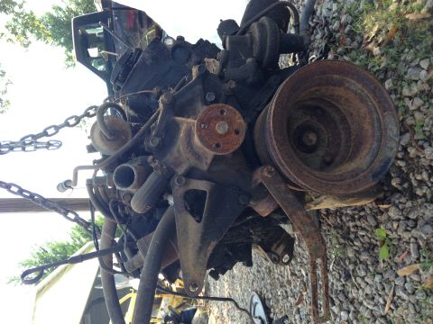 1987 Ford Ranger - An engine block, covered in rust and grime, is suspended by chains.