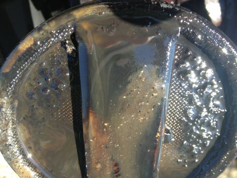 1987 Ford Ranger - This oil pan is filled with thick, dark sludge, indicating potential engine issues.